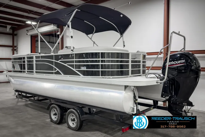 Slide: The Image of 2022 Bennington 23 LSR pontoon boat with Mercury engine on trailer in showroom. - 6