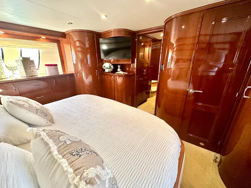 Slide: The Image of Luxurious 2007 Marquis 59 yacht bedroom with elegant wood paneling and cozy bedding. - 44