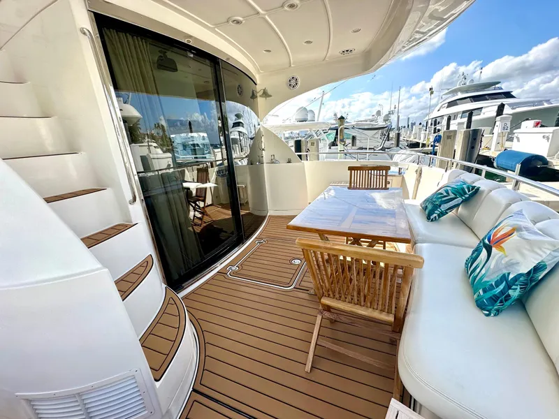 Slide: The Image of Luxurious 2007 Marquis 59 Markham Edition yacht deck with seating and table, docked at marina. - 9