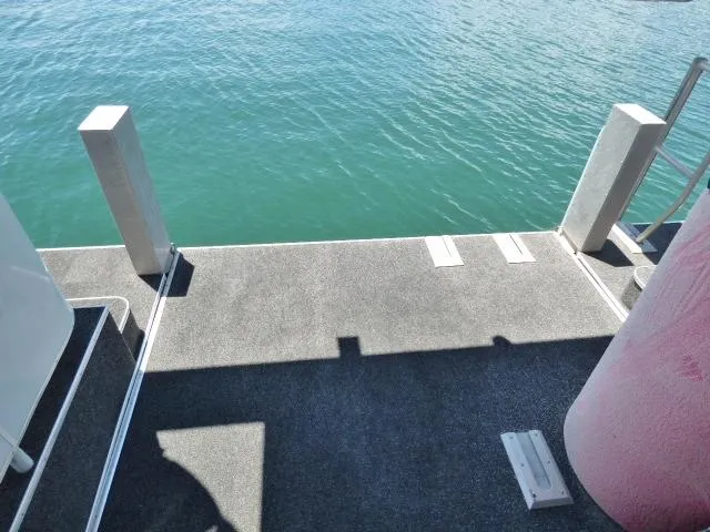 Slide: The Image of Sumerset 19x105 houseboat deck overlooking calm water, 2009 model. - 14