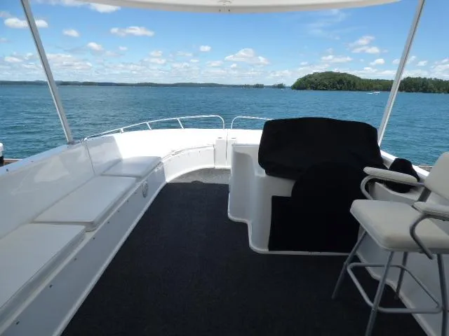 Slide: The Image of 2009 Sumerset 19x105 houseboat deck with seating, overlooking serene lake and blue sky. - 16