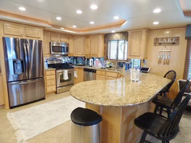 Slide: The Image of Luxurious kitchen in 2009 Sumerset 19x105 houseboat with granite countertops and stainless steel appliances. - 4