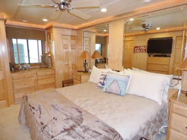 Slide: The Image of Luxurious bedroom in 2009 Sumerset 19x105 houseboat with nautical decor and wooden furnishings. - 7