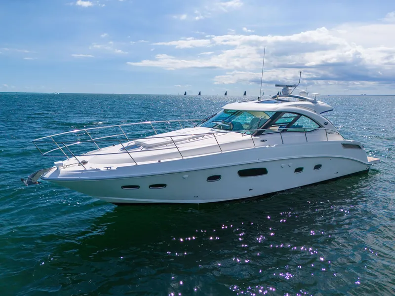 Slide: The Image of 2011 Sea Ray 470 Sundancer yacht cruising on open water under a clear sky. - 12