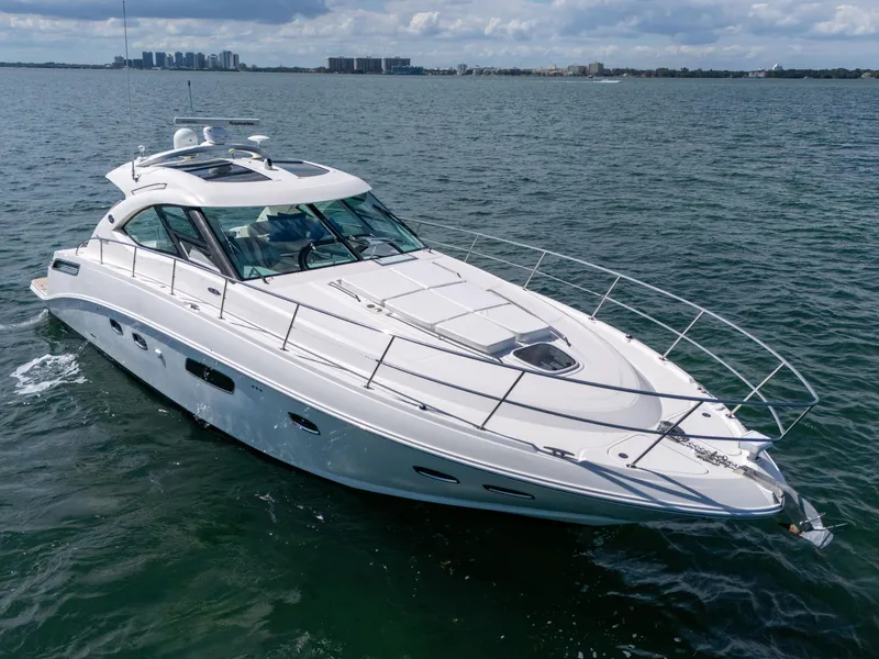 Slide: The Image of 2011 Sea Ray 470 Sundancer yacht cruising on open water under cloudy skies. - 14