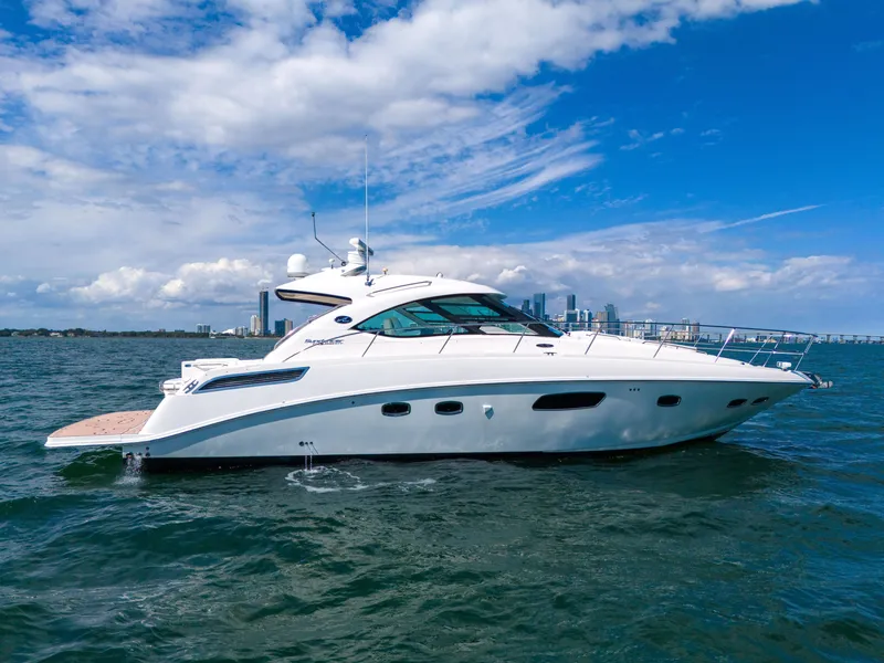 Slide: The Image of 2011 Sea Ray 470 Sundancer yacht cruising on open water under a clear blue sky. - 2
