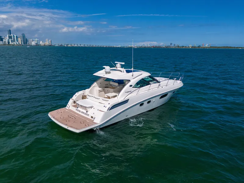 Slide: The Image of 2011 Sea Ray 470 Sundancer yacht cruising on open water near city skyline. - 24