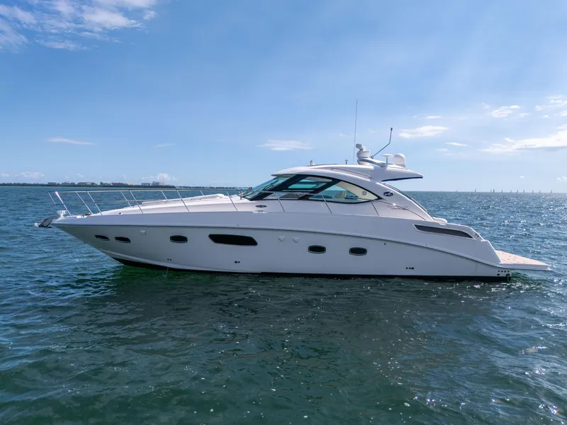 Slide: The Image of 2011 Sea Ray 470 Sundancer yacht cruising on open water under clear blue skies. - 27