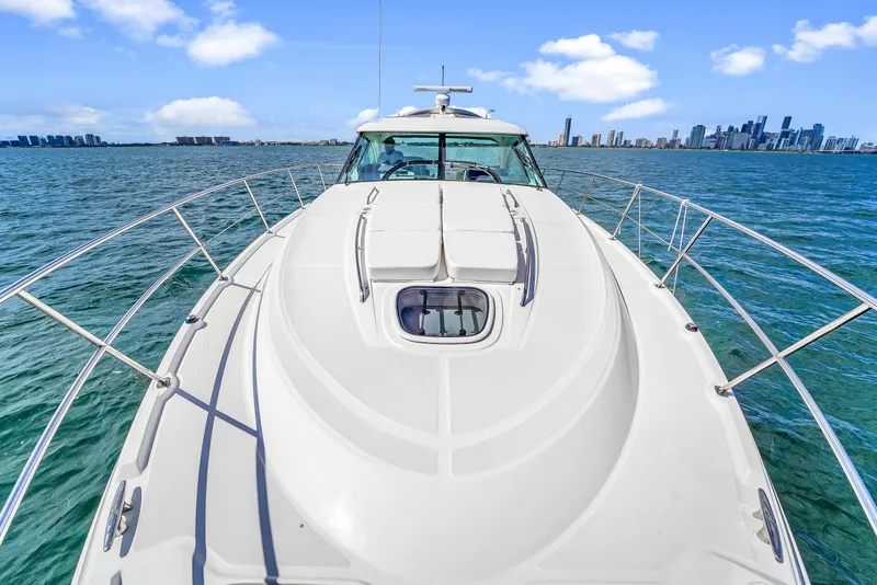 Slide: The Image of Sea Ray 470 Sundancer 2011 yacht cruising on open water with city skyline in background. - 30