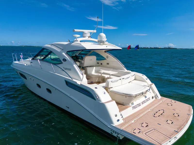 Slide: The Image of 2011 Sea Ray 470 Sundancer yacht on open water, showcasing sleek design and spacious deck. - 32