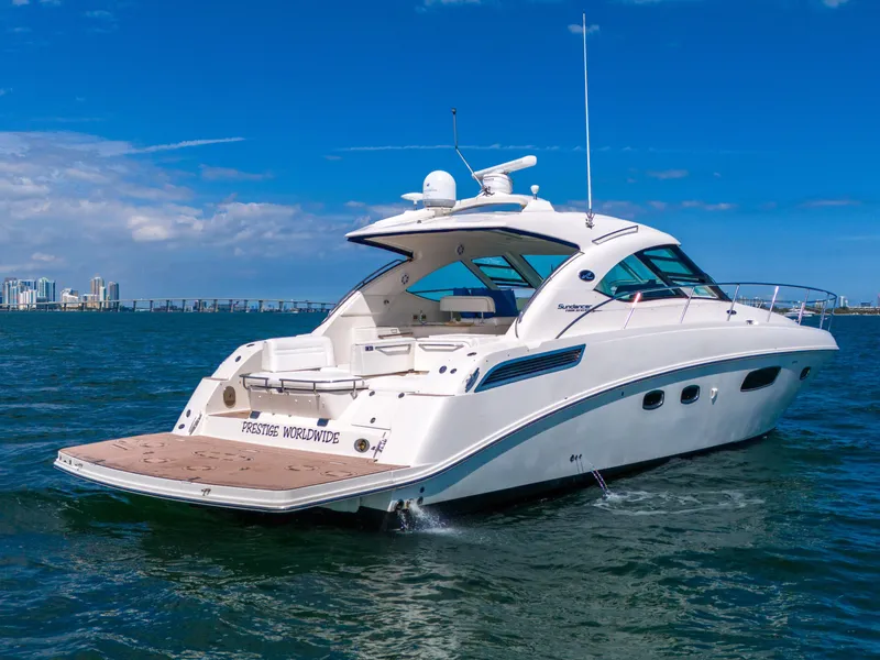 Slide: The Image of 2011 Sea Ray 470 Sundancer yacht cruising on open water under a clear blue sky. - 37