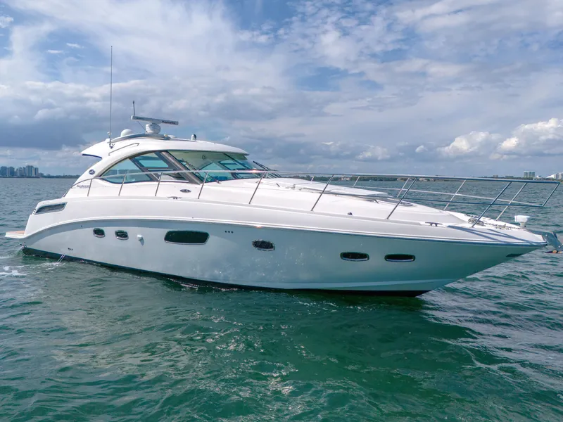 Slide: The Image of 2011 Sea Ray 470 Sundancer yacht cruising on open water under a cloudy sky. - 4