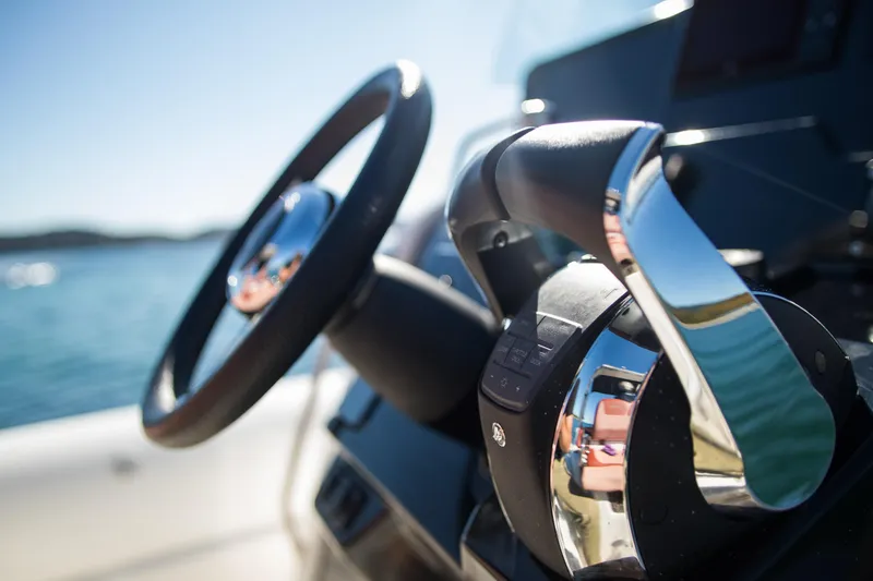 Slide: The Image of Close-up of 2025 Zodiac Medline 9 boat controls with steering wheel and throttle. - 16