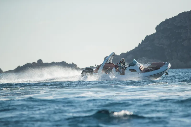 Slide: The Image of 2025 Zodiac Medline 9 speeding on the ocean near rocky coastline. - 23