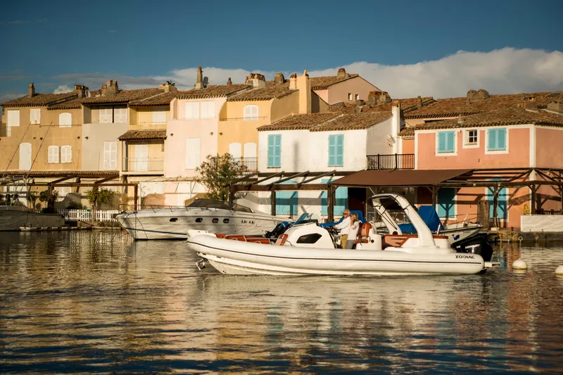 Slide: The Image of 2025 Zodiac Medline 9 boat cruising near colorful waterfront houses. - 7