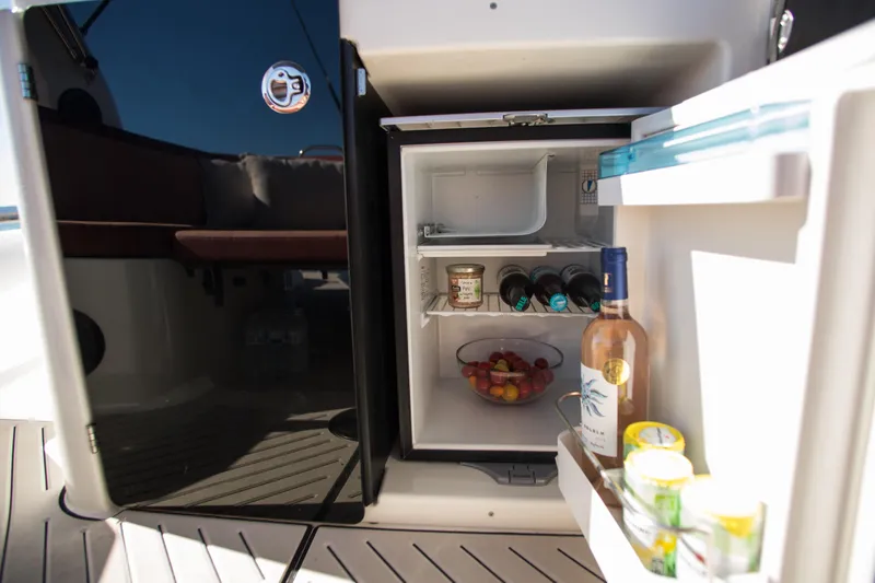 Slide: The Image of Open mini fridge on Zodiac Medline 9 boat, stocked with drinks and snacks, 2025 model. - 8