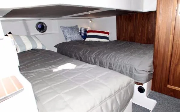 Slide: The Image of 2025 Sargo EXPLORER cabin with twin beds and nautical-themed pillows. - 6