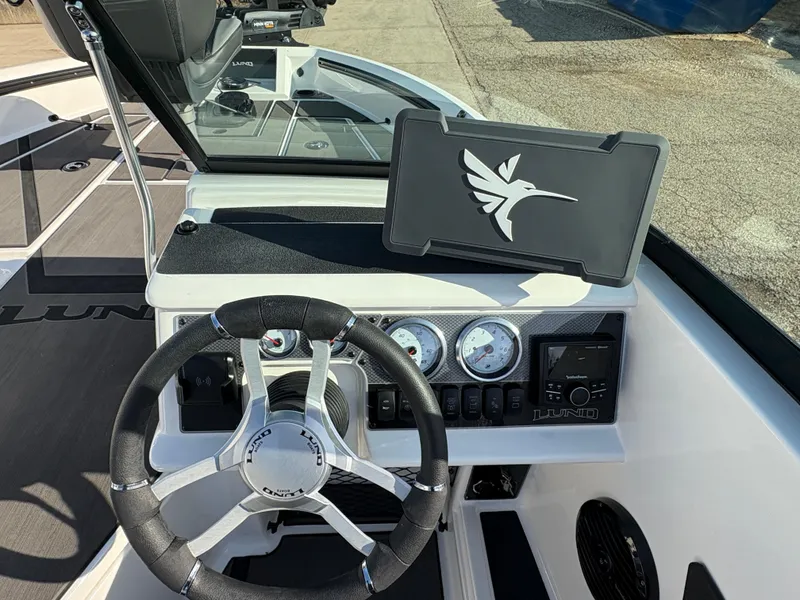 Slide: The Image of 2025 Lund 185 Impact GL boat dashboard with steering wheel and gauges. - 26