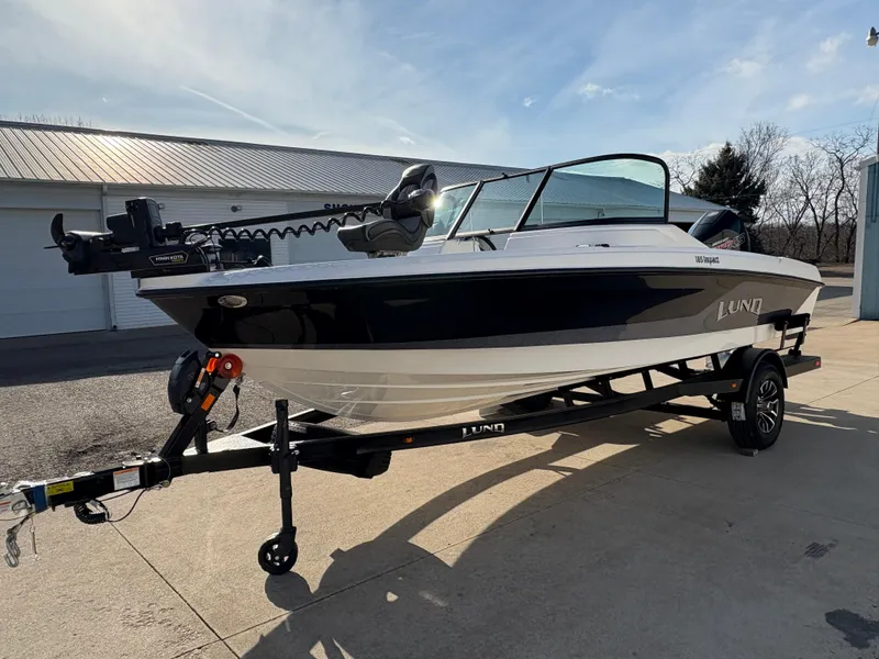 Slide: The Image of 2025 Lund 185 Impact GL boat on trailer, parked outdoors, side view. - 5