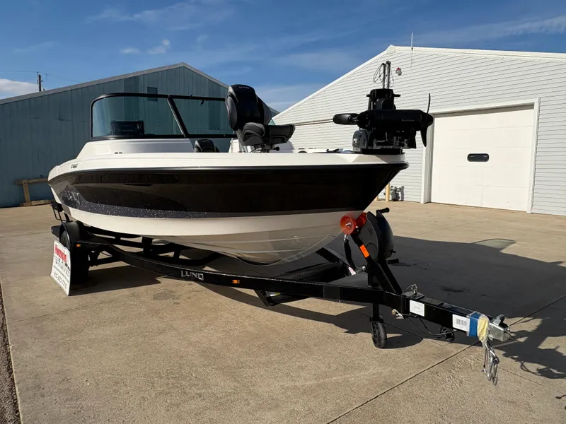 Slide: The Image of 2025 Lund 185 Impact GL boat on trailer, parked outside a garage. - 7