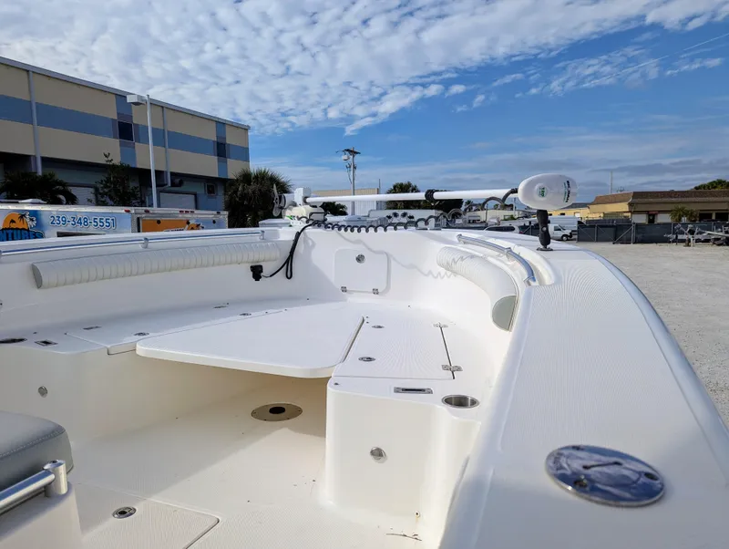 Slide: The Image of 2021 Sea Born LX26 boat interior with seating and storage, under a partly cloudy sky. - 26