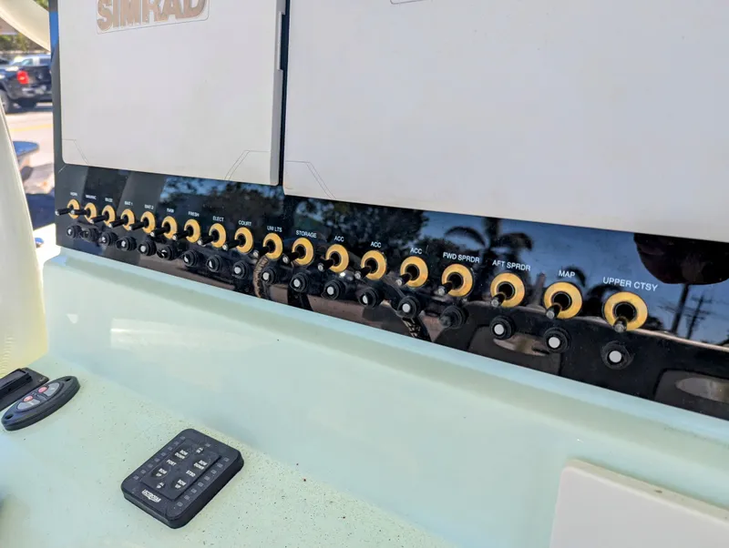 Slide: The Image of Control panel of a 2021 Sea Born LX26 boat with multiple switches and Simrad electronics. - 8