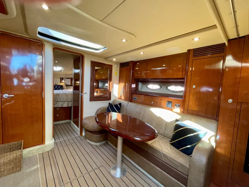 Slide: The Image of Interior of 2005 Sea Ray 390 Sundancer yacht with wood finish and cozy seating area. - 17