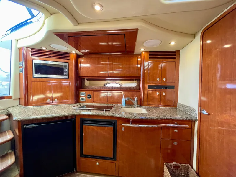 Slide: The Image of Luxurious kitchen interior of 2005 Sea Ray 390 Sundancer yacht with wood cabinetry and modern appliances. - 20