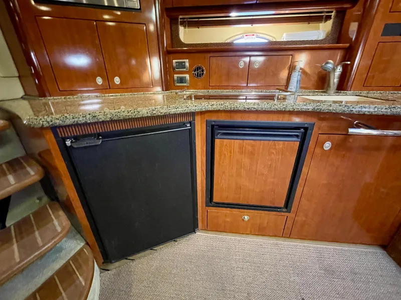 Slide: The Image of Luxurious 2005 Sea Ray 390 Sundancer yacht kitchen with wood cabinetry and granite countertops. - 30