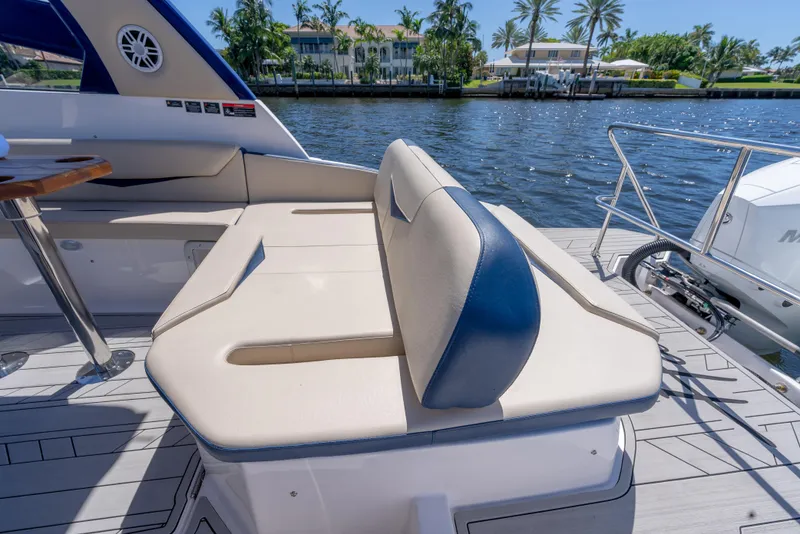 Slide: The Image of Luxury seating on 2025 Hanover 305 Outboard boat, docked by scenic waterfront. - 10