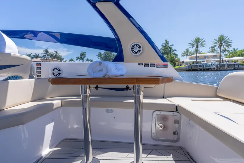 Slide: The Image of 2025 Hanover 305 Outboard boat interior with table, seating, and waterfront view. - 12