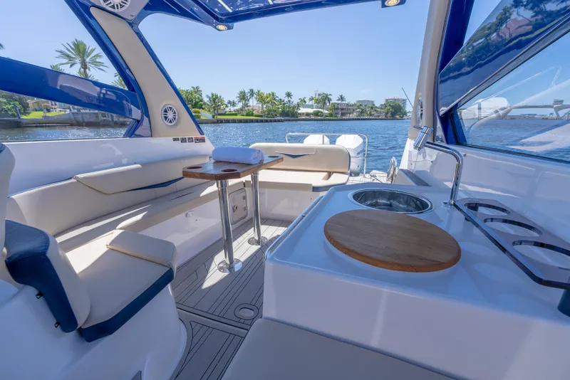 Slide: The Image of Luxurious interior of 2025 Hanover 305 Outboard boat with seating and kitchenette by the water. - 9