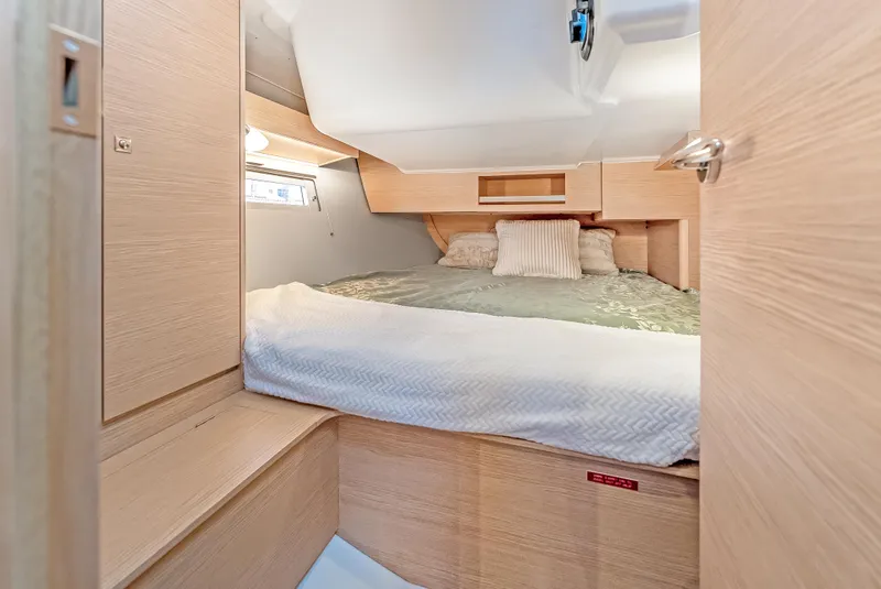 Slide: The Image of Cozy cabin interior of 2023 Dufour 390 yacht with a comfortable bed and wooden finish. - 24