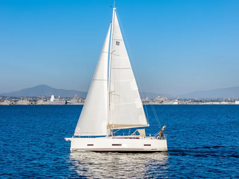 Slide: The Image of 2023 Dufour 390 sailboat cruising on a calm blue sea. - 5