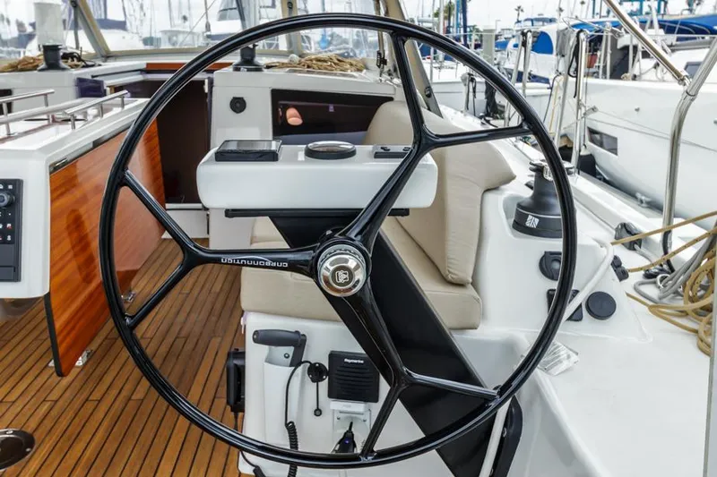 Slide: The Image of Dufour 390 yacht steering wheel, 2023 model, with teak deck and modern cockpit design. - 6