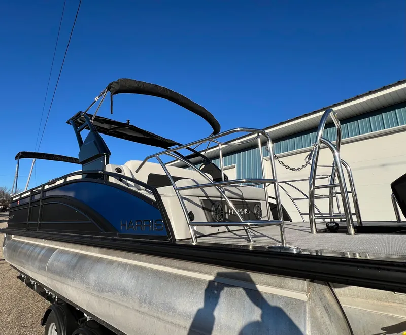 Slide: The Image of 2023 Harris Solstice 250 pontoon boat on trailer under clear blue sky. - 19