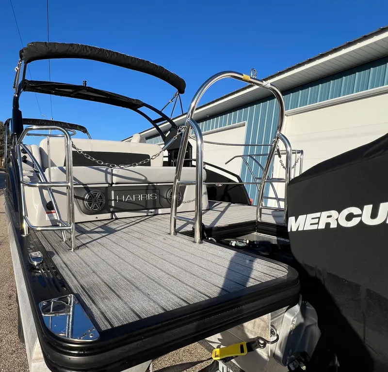 Slide: The Image of 2023 Harris Solstice 250 boat with Mercury engine, docked under clear blue sky. - 20