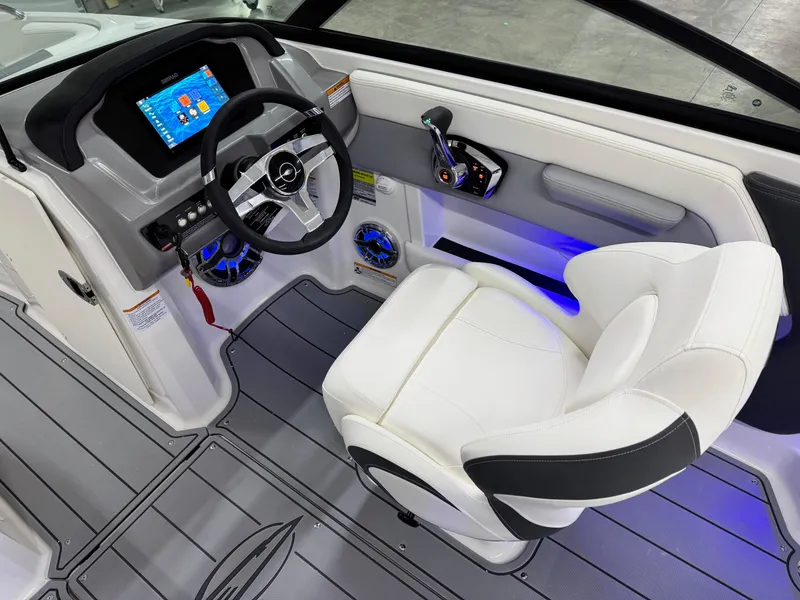 Slide: The Image of 2025 Chaparral 21 Surf boat interior with modern dashboard and white captain's chair. - 10