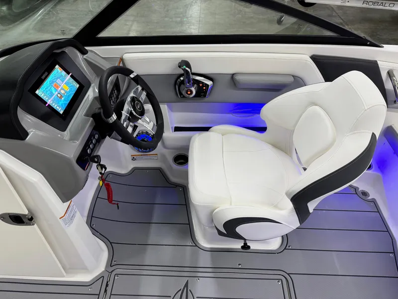 Slide: The Image of 2025 Chaparral 21 Surf boat interior with modern dashboard and white captain's chair. - 11