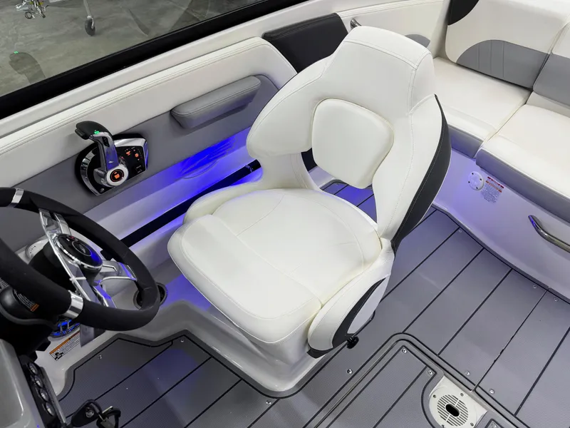Slide: The Image of 2025 Chaparral 21 Surf boat interior with white captain's chair and modern controls. - 16