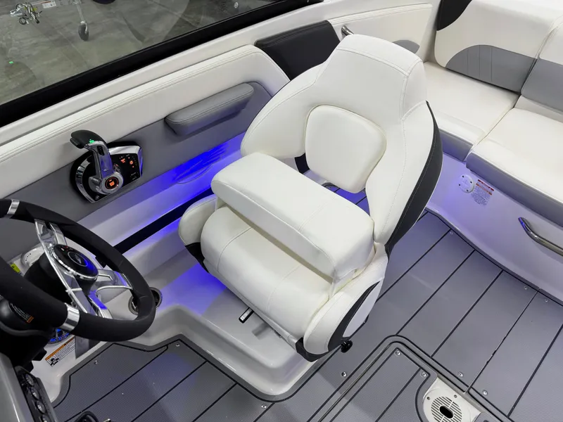 Slide: The Image of 2025 Chaparral 21 Surf boat interior with white captain's chair and blue LED lighting. - 17