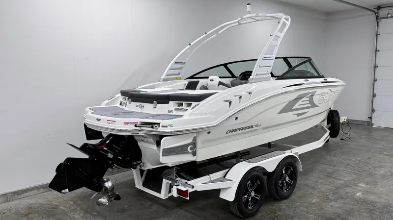 Slide: The Image of 2025 Chaparral 21 Surf boat on trailer in a garage setting. - 2