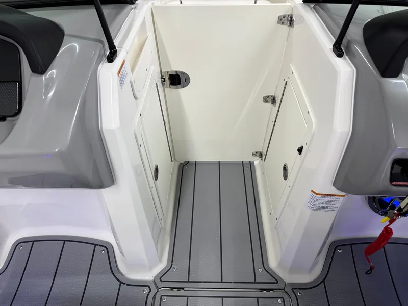 Slide: The Image of 2025 Chaparral 21 Surf boat interior with gray flooring and white storage compartments. - 30