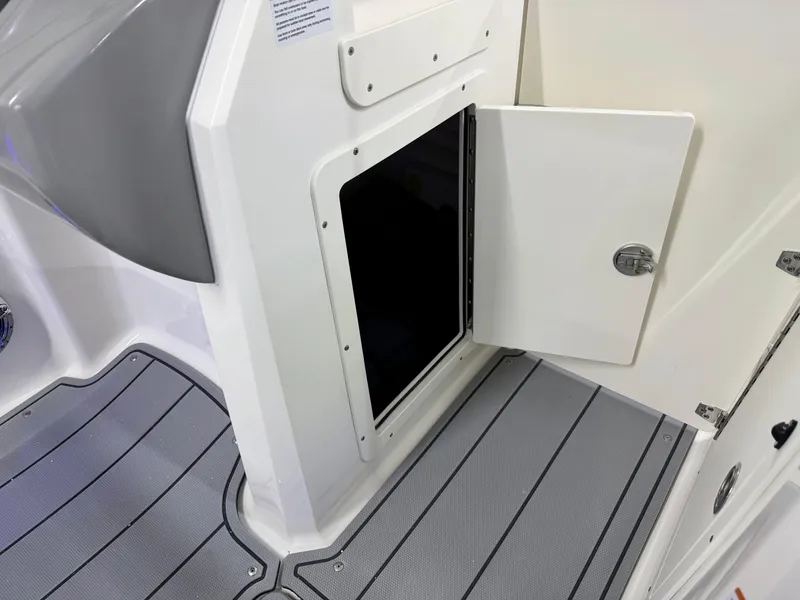 Slide: The Image of 2025 Chaparral 21 Surf boat interior storage compartment with open door. - 32