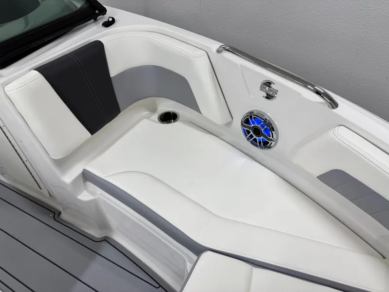 Slide: The Image of 2025 Chaparral 21 Surf boat interior with white and gray seating, blue speaker detail. - 35