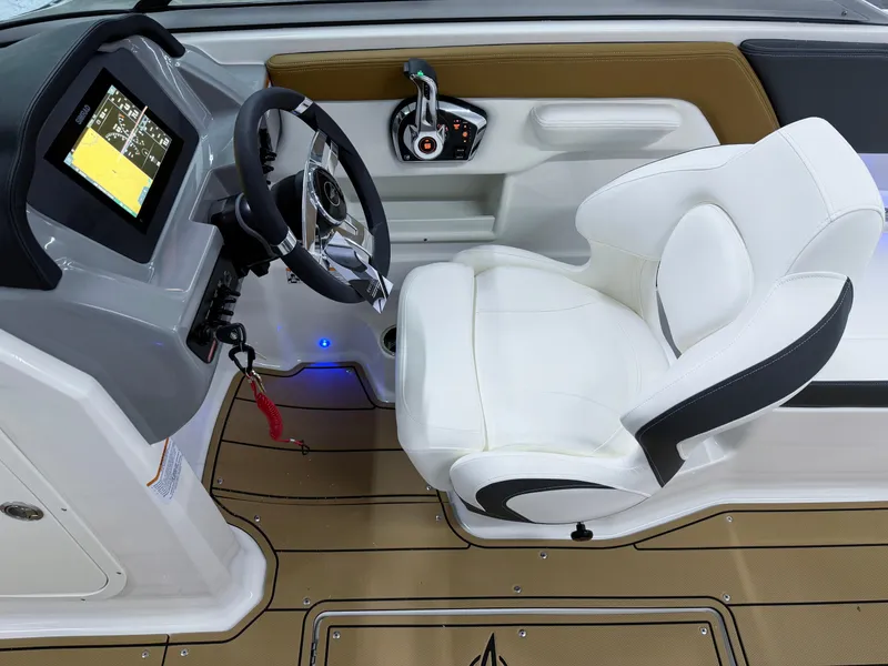 Slide: The Image of 2025 Chaparral 23 SSi boat cockpit with steering wheel and white captain's chair. - 11