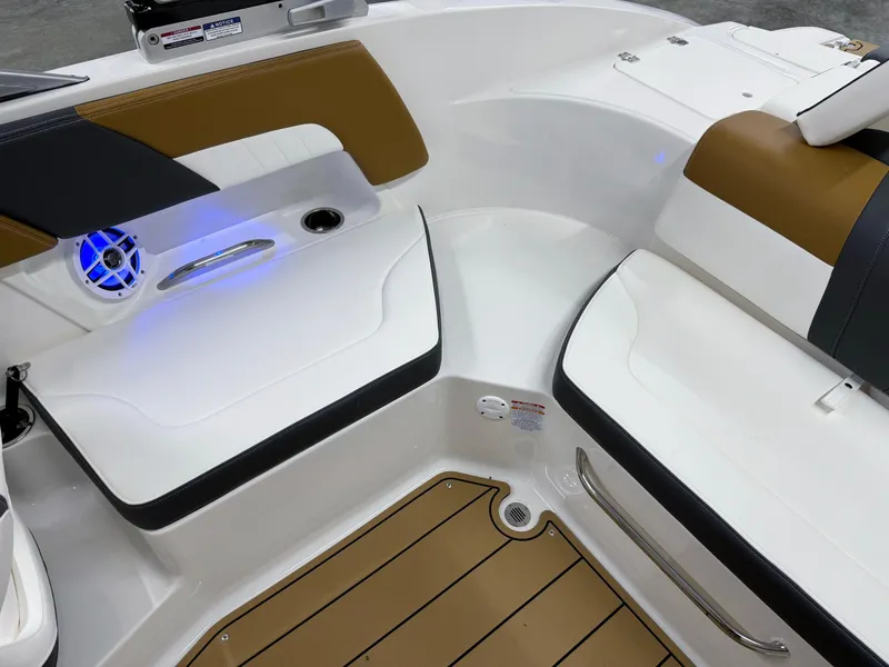 Slide: The Image of 2025 Chaparral 23 SSi boat interior with brown and white seating, blue LED lighting. - 18