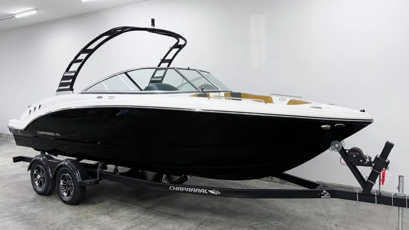 Slide: The Image of 2025 Chaparral 23 SSi boat on trailer, sleek black and white design. - 2