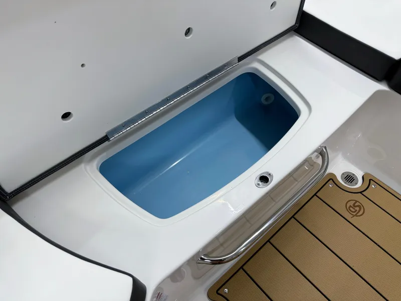 Slide: The Image of 2025 Chaparral 23 SSi boat storage compartment with blue interior and teak-style flooring. - 21