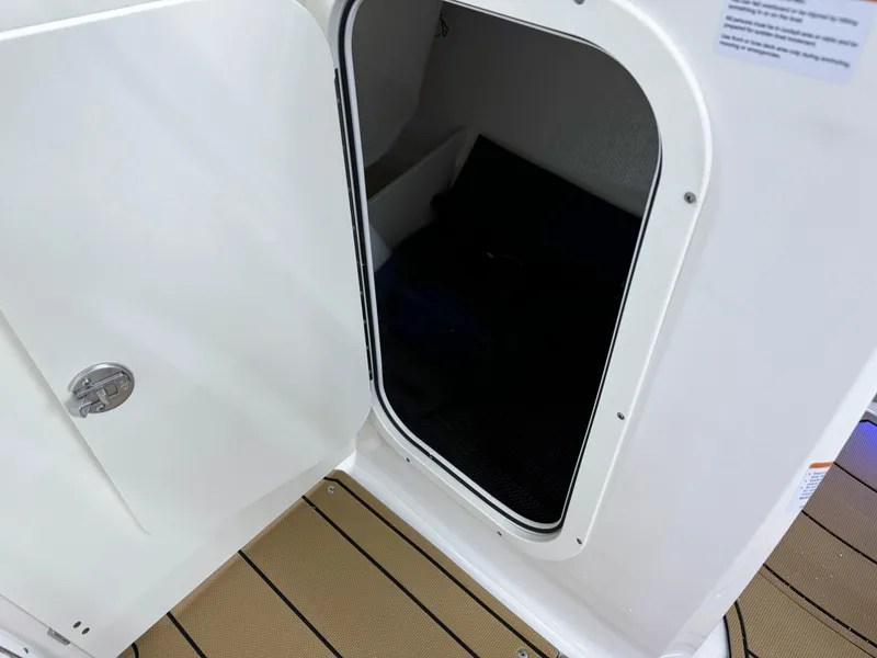Slide: The Image of 2025 Chaparral 23 SSi boat cabin entrance with open door, showcasing interior space. - 30